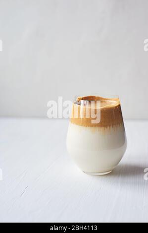 Kalte Kaffeesahne mit kalter Dalgon-Milch.Trend. In einem transparenten Glas auf weißem Hintergrund. Stockfoto