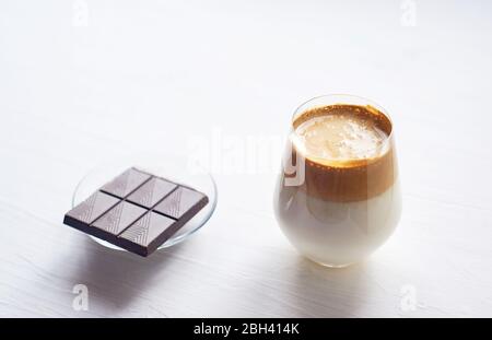 Kalte Kaffeesahne mit kalter Dalgon-Milch.Trend. In einem transparenten Glas auf weißem Hintergrund. Stockfoto