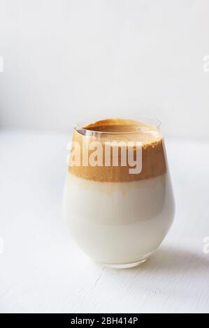 Kalte Kaffeesahne mit kalter Dalgon-Milch.Trend. In einem transparenten Glas auf weißem Hintergrund. Stockfoto