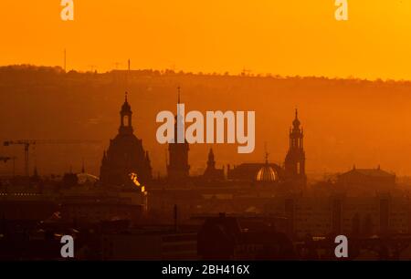 Dresden, Deutschland. April 2020. Die Sonne geht abends am Horizont hinter der Innenstadt mit der Frauenkirche, dem Hausmannsturm, dem Ständehaus, der Kuppel der Akademie der Künste mit dem Engel Fama, der Hofkirche und der Semperoper unter. Quelle: Robert Michael/dpa-Zentralbild/dpa/Alamy Live News Stockfoto