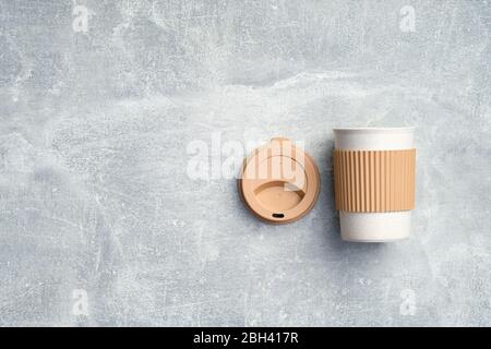 Umweltfreundliche zum Mitnehmen Kaffee Tasse auf Stein Hintergrund. Wiederverwendbare braune Bambustasse. Zero Waste, nachhaltiges Lifestyle-Konzept. Flach liegend, Draufsicht Stockfoto