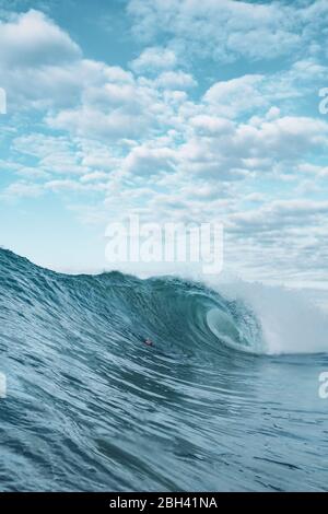 Eine Welle bricht auf einem Riff in einem tropischen Paradies Strand Stockfoto