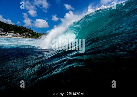 Eine Welle bricht auf einem Riff in einem tropischen Paradies Strand Stockfoto