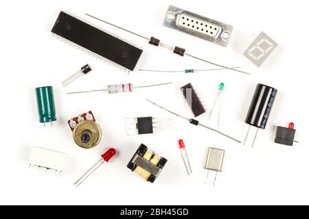 Verschiedene elektronische Bauteile oder Bauteile auf weißem Hintergrund mit Widerständen, Kondensatoren, Dioden und IC-Chips, flache Ansicht von oben Stockfoto