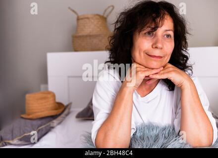 Nahaufnahme der positiven älteren weiblichen Rentner sitzen entspannen zu Hause Blick in der Ferne Fenster träumen oder visualisieren, lächelnd reife Frau Großmutter in Gedanken verloren erinnern gut. Quarantänezeitraum Stockfoto