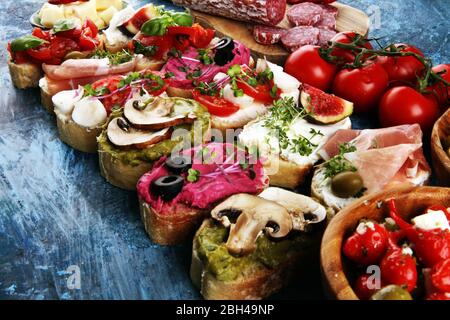 Sortierte Bruschetta mit verschiedenen Belägen. Appetitlich Bruschetta oder Crudo Crostini. Auswahl an kleinen Sandwiches. Bruschetta mischen Stockfoto