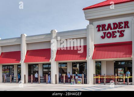 Kunden, die Masken tragen und soziale Distanz in der Schlange warten, um New Orleans Area Trader Joe's Lebensmittelgeschäft während Covid-19, Coronavirus Pandemie zu betreten. Stockfoto