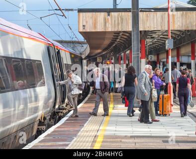 Bahnreisende, die einen Virgin Trains Pendolino Zug am Bahnhof Lancaster besteigen und verlassen Stockfoto