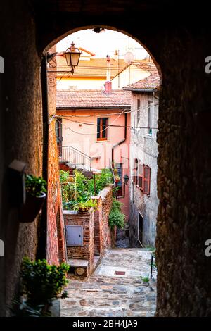 Chiusi, Italien schmale leere Gasse in kleinen historischen Dorf in der Toskana bunte Wände von Häusern und Stein Gewölbe Bogen Stockfoto