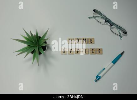 Das Wort Home Office in hölzernen Buchstabenfliesen auf weißem Hintergrund geschrieben. Konzeptarbeit von zu Hause, Technologie, Arbeitsplatz und Lifestyle. Stockfoto