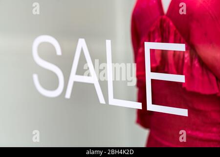 Einkaufszentrum Abteilung Kleidung Mode Shop Shop Schaufenster Schild Nahaufnahme des Verkaufs auf Glasfenster Nahaufnahme außen mit Schaufensterpuppe und Kleidung Stockfoto