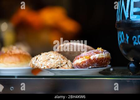 Café oder Restaurant Straßenfenster Display in der Altstadt Marktplatz Warschau, Polen mit Donuts Donut, Mandeln Brot-Gebäck auf Teller in Chri Stockfoto