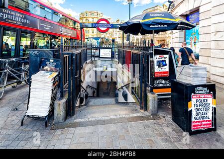 London, Großbritannien - 21. Juni 2018: U-Bahnstation in Charing Cross Exterior mit Schild für Zeitungsstand und roten Doppeldeckerbus im Sommer Stockfoto