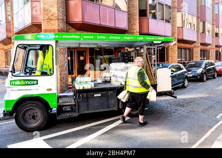 London, Großbritannien - 22. Juni 2018: Nachbarschaft von Westminster mit Mann, der Milch mit Krügen mit grünem LKW und Schild bringt Stockfoto