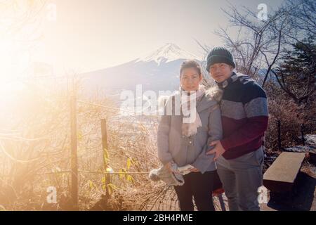 Ein Paar macht ein Foto mit dem Berg Fuji als Hintergrund mit klarem blauen Himmel in Kawaguchiko Stadt. Tokio, Japan 9. Februar 2020 Stockfoto