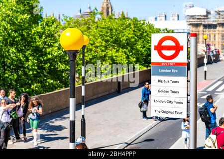 London, Großbritannien - 22. Juni 2018: Blick über die Big Bus Haltestelle mit Leuten, die auf dem Bürgersteig der Straße laufen und Hinweisschild zum London Eye Stockfoto