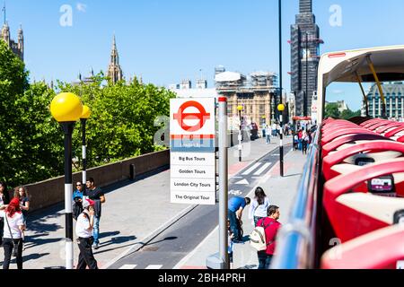 London, Großbritannien - 22. Juni 2018: Blick über die Big Bus Haltestelle mit Leuten, die auf dem Bürgersteig der Straße laufen und Hinweisschild zum London Eye Stockfoto