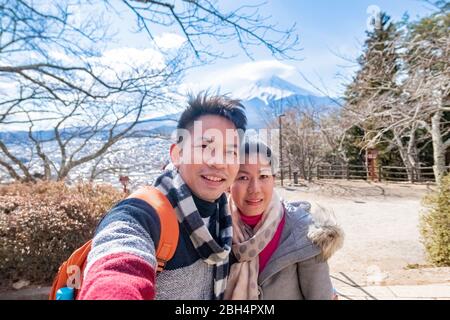 Ein Paar macht ein Foto mit dem Berg Fuji als Hintergrund mit klarem blauen Himmel in Kawaguchiko Stadt. Tokio, Japan 9. Februar 2020 Stockfoto