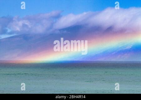 Elektrischer Regenbogen schwebt über dem Ozean mit Molokai im Hintergrund auf Maui. Stockfoto
