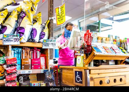 Reston, USA - 9. April 2020: Soziale Distanzierung Zeichen an der Kasse Check-out Gang im Trader Joe's Lebensmittelgeschäft während Coronavirus mit Frau em Stockfoto