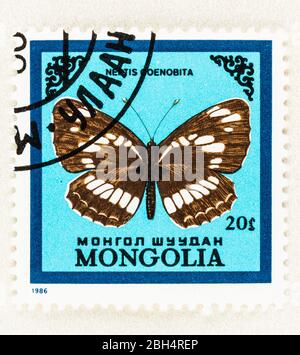 SEATTLE WASHINGTON - 21. April 2020: 1986 Mongolische Briefmarke mit Neptis coenobita Schmetterling auf blauem Hintergrund. AKA Sailer Butterfly. Schotte Stockfoto