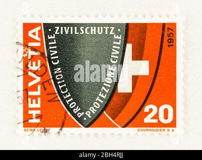 SEATTLE WASHINGTON - 18. April 2020: 1957 Schweizer Briefmarke, die die Schweizer Zivilverteidigung bekannt macht, mit Schilden mit Inschrift und nationaler Coat o Stockfoto