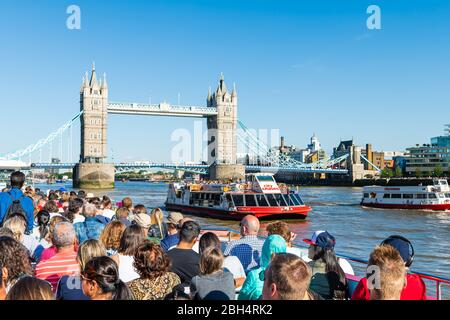 London, Großbritannien - 22. Juni 2018: Viele Touristen sitzen in Boot Kreuzfahrt Tour auf der Themse mit Blick auf die Stadt Tower Brücke und Citykreuzfahrten Schiff Stockfoto