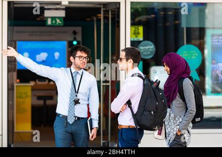 London, Großbritannien - 26. Juni 2018: Junge Leute sprechen mit Geschäftsleuten auf der Straße auf dem Bürgersteig im Zentrum der Innenstadt von England Stockfoto