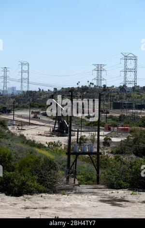 Hochspannungsleitungen, die durch ein Ölfeld im Süden Kaliforniens verlaufen Stockfoto