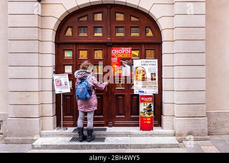 Warschau, Polen - 21. Dezember 2019: Marktplatz der Altstadt mit Frau am Eingang des Museums der Erzdiözese mit Chopin-Klavier live conc Stockfoto