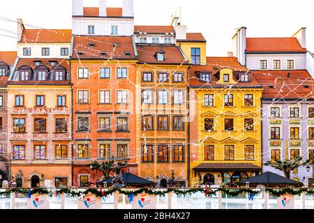 Warschau, Polen - 21. Dezember 2019: Leerer Marktplatz der Altstadt farbenfrohe historische Architekturgebäude in Warszawa mit weihnachtlicher Beleuchtung Stockfoto