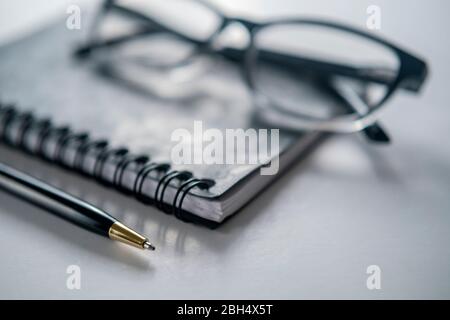 Brille, Notizbuch und Stift Stockfoto