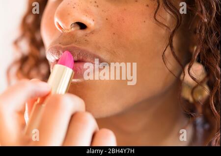 Frau Auftragen von Lippenstift Stockfoto