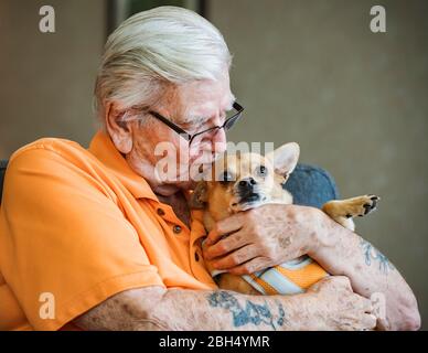 Älterer Mann küsst Hund Stockfoto
