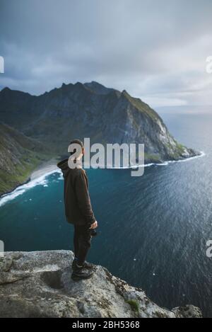 Mann mit Kamera auf einer Klippe am Ryten-Berg auf den Lofoten-Inseln, Norwegen Stockfoto