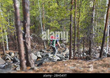 Blick auf einen Wandertouristen, der durch die Steine im Hochland wandert. Aktives Lifestyle- und Gesundheitskonzept. Stockfoto