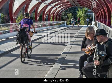 Straßenmusikanten, Biker am Frieden Brücke, Fußgängerbrücke über Bow River in der Nähe der Innenstadt von Calgary, Alberta, Kanada Stockfoto