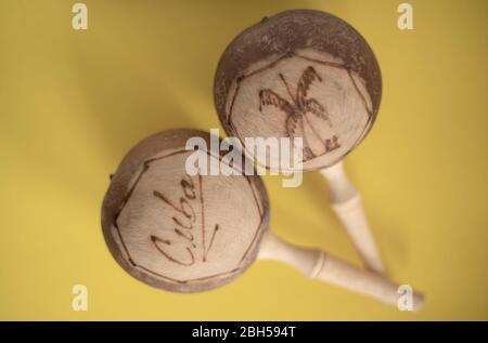 Kubanische Maracas. Traditionelle Musikinstrument isoliert Nahaufnahme aus Holz natürlichen Materialien auf gelbem Hintergrund Stockfoto