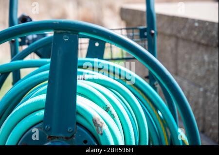 Selektiver Fokus auf die vordere Bar auf einem gewickelten Gartenschlauch-Aufbewahrungswagen Stockfoto