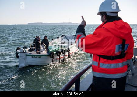 23. April 2020, Schleswig-Holstein, Helgoland: Jörg Singer (l.), Bürgermeister von Helgoland, kommt an der Boje-Schicht 'Lev Taifun' vorbei und begrüßt ihn. Startschuss für ein großes maritimes Testfeld vor Helgoland: Wissenschaftler des Testzentrums für Maritime Technologien haben in Fässern eine Fläche von drei Millionen Quadratmetern unweit der Nordseeinsel markiert. Es soll künftig Testeinrichtungen für die maritime Robotik bereitstellen. Hersteller und Wissenschaftler können dort verschiedene Szenarien testen. So können beispielsweise autonome Unterwasserfahrzeuge für Offshore-Windenergieanlagen unter Real getestet werden Stockfoto