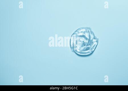 Kosmetisches Gel auf blauem Hintergrund. Handdesinfektionsmittel, Alkoholgel, Feuchtigkeitspflege. Klare transparente Hautpflege Produkt Probe Nahaufnahme Stockfoto
