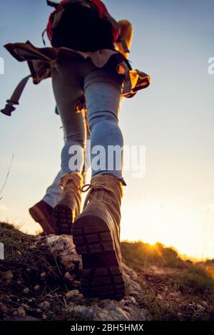 Ein Touristenpaar mit Wanderschuhen geht einen grasbewachsenen Hügel in den Alpen hinauf. Stockfoto