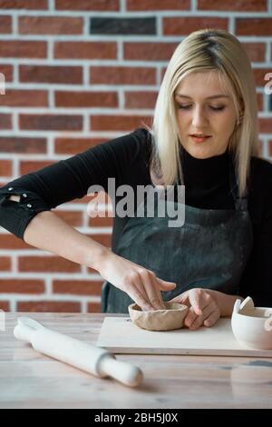 Frau macht Keramik Keramik. Konzept für Frau in freiberuflicher, geschäftlicher. Handwerkliches Produkt. Verdienen Sie mehr Geld, Side Hustle, Hobbys in Bargeld Stockfoto