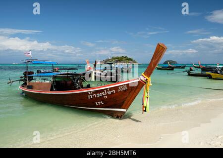 Taxi Boot am Sonnenaufgangsstrand thailand asien, mit klarem blauen Wasser und blauem Himmel, koh Usen Insel im Hintergrund. Stockfoto