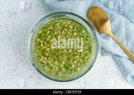 Einweichen von grünem Erbsengetreide in Wasser zum Gären von Getreide und zur Neutralisierung von Phytsäure. Stockfoto