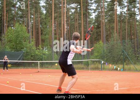 Rückansicht eines männlichen Tennisspielers mit einem Schläger, der auf einen Pass des Gegners wartet Stockfoto