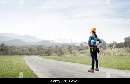 Junge Frau in Schutzhelm stehen auf der Straße Stockfoto