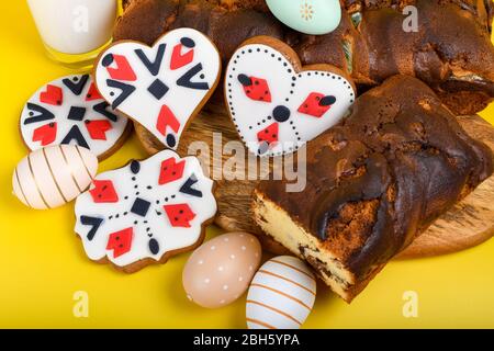 Scheiben von rumänischen Biskuit mit roten traditionellen Handtuch mit Handstich auf Holzbrett, Ostern bemalte Eier und hausgemachte Ingwer Brot Herzen, EIN Stockfoto