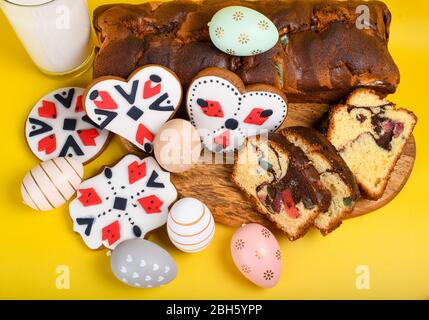 Scheiben von rumänischen Biskuit mit roten traditionellen Handtuch mit Handstich auf Holzbrett, Ostern bemalte Eier und hausgemachte Ingwer Brot Herzen, EIN Stockfoto