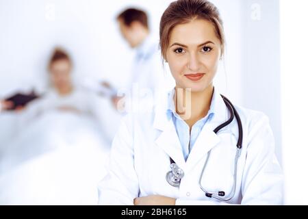 Lächelnd auf den Hintergrund mit Patienten im Bett und zwei Ärzte Ärztin Stockfoto